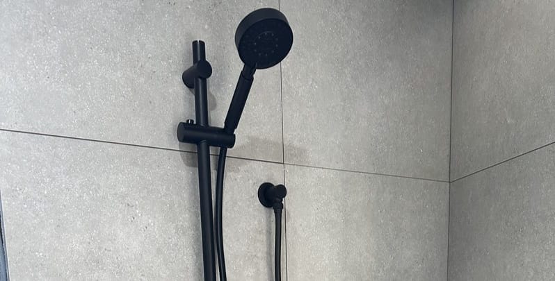 Matte black shower head, installed as part of a plumbing renovation. 