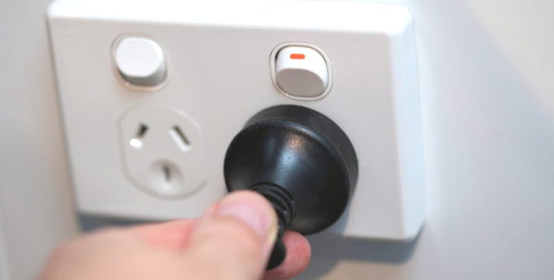 Person inserting a plug into an unprotected Australian power point.